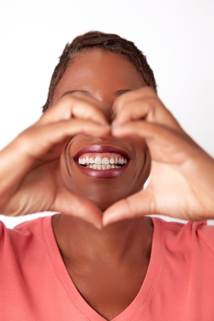 Smiling through a heart sign - 868 Dental Studio